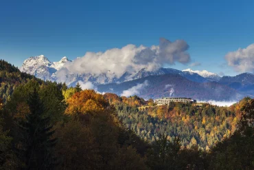 Le Kempinski Hotel Berchtesgaden sur le plateau de l'Eckerbichl, entouré de forêts d'automne, face aux sommets enneigés des Alpes de Berchtesgaden