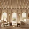 Rendu d'une chambre deluxe du Mas Bellevue à Saint-Tropez, poutres claires, boiseries et trois fenêtres en arc ouvertes sur la mer