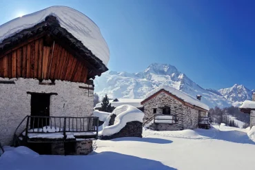 Le hameau classé du Monal sous la neige, chalets de pierre et de bois face au Mont Pourri, à Sainte-Foy-Tarentaise