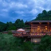 Le pavillon principal de Pemako Punakha illuminé au crépuscule dans la forêt de la vallée de Punakha, au Bhoutan