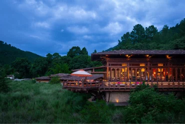 Le pavillon principal de Pemako Punakha illuminé au crépuscule dans la forêt de la vallée de Punakha, au Bhoutan