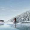 Piscine extérieure chauffée du Lefay Resort & SPA Dolomiti face aux forêts enneigées