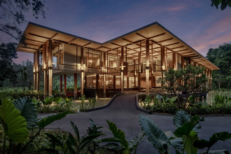 Le bâtiment de Layan Life by Anantara éclairé à la tombée de la nuit, dans la végétation de l'Anantara Layan Phuket Resort