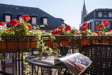 Un balcon fleuri de la Maison Rouge Strasbourg avec vue sur la cathédrale