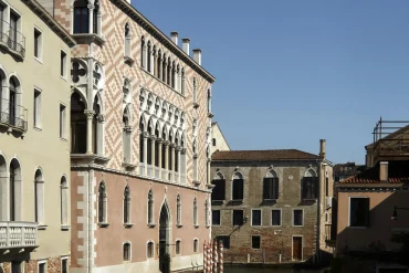 La façade gothique rose et blanche du Palazzo Donà Giovannelli sur le canal, devenu l'hôtel Orient Express Venezia