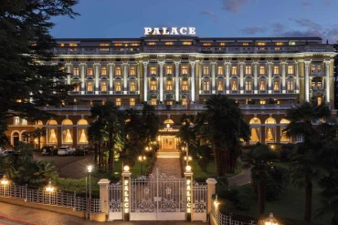 La façade illuminée du Palace Merano et son parc, le soir, à Merano