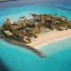 Rendu d'une résidence Aman Residences Amanolu occupant sa propre île privée, plage des deux côtés et ponton, atoll de Vaavu aux Maldives
