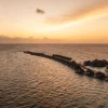 Vue aérienne au coucher du soleil des villas sur pilotis du Constance Halaveli Maldives, atoll d'Ari Nord