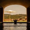 Bassin intérieur du spa de Viceroy at Ombria Algarve ouvert sous une arche sur les collines de l'Algarve