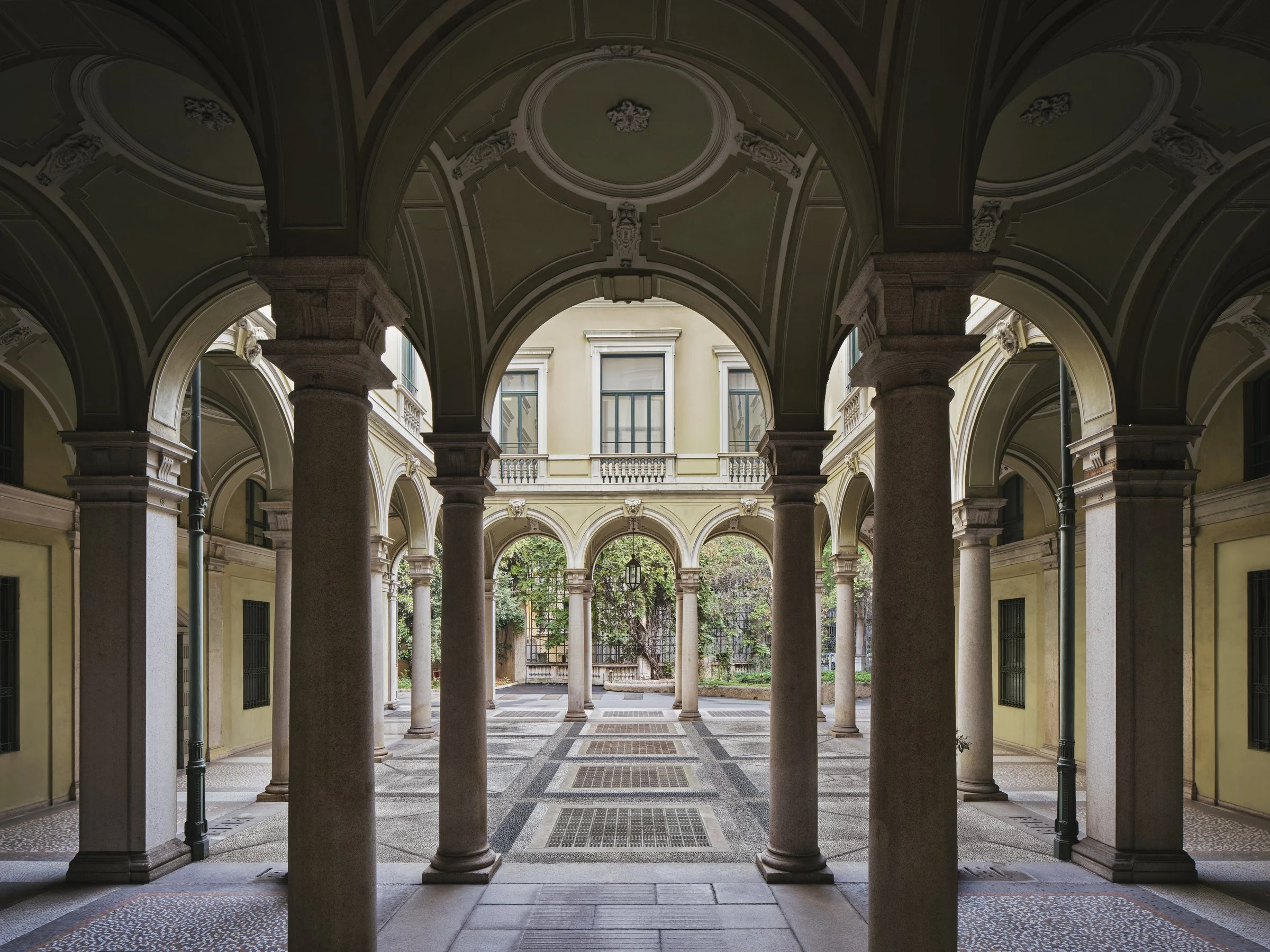 La cour à arcades et colonnes de pierre du palais du XIXe siècle qui accueillera le Rosewood Milan, ouverte sur un jardin