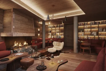 Le lounge de l'hôtel The Ski Lodge à Verbier, cheminée, bibliothèque et banquettes rouges, visuel de présentation