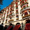 La façade du Plaza Athénée, ses balcons fleuris et ses stores rouges, avenue Montaigne à Paris