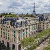 Vue aérienne de l'hôtel The Peninsula Paris, avenue Kléber, avec la tour Eiffel à l'horizon