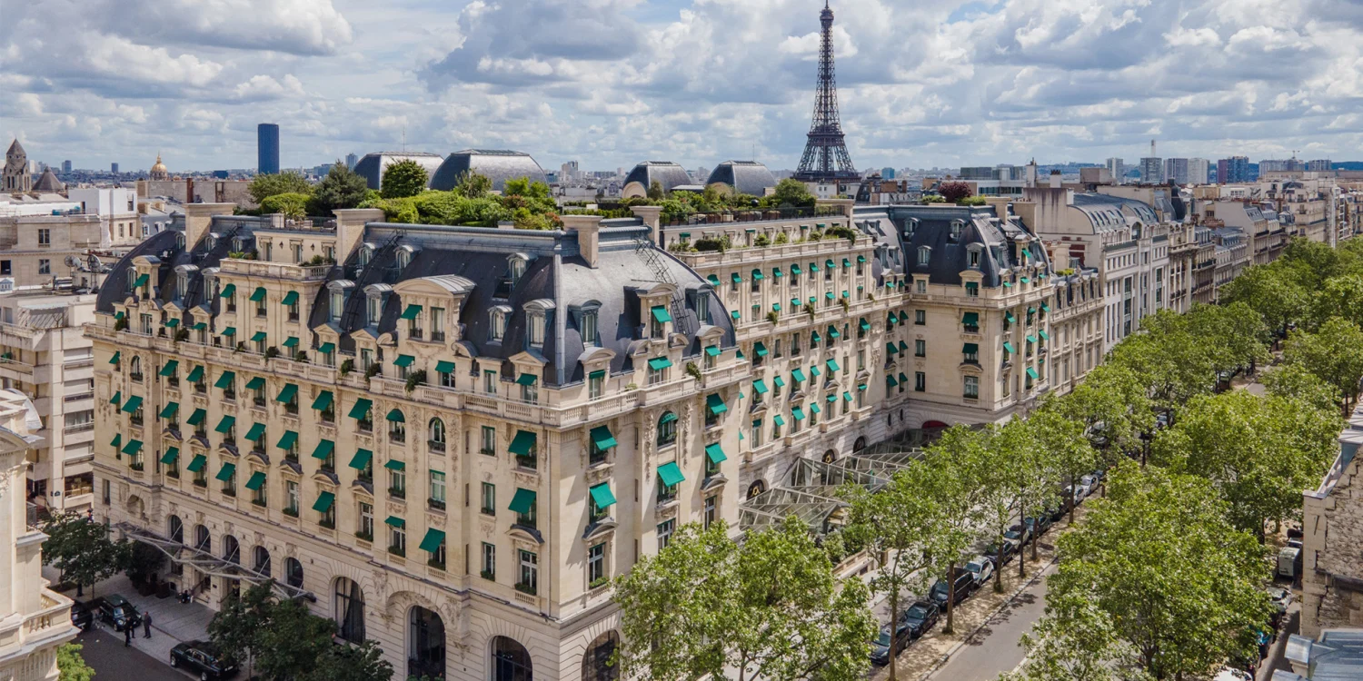Vue aérienne de l'hôtel The Peninsula Paris, avenue Kléber, avec la tour Eiffel à l'horizon