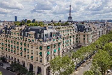 Vue aérienne de l'hôtel The Peninsula Paris, avenue Kléber, avec la tour Eiffel à l'horizon