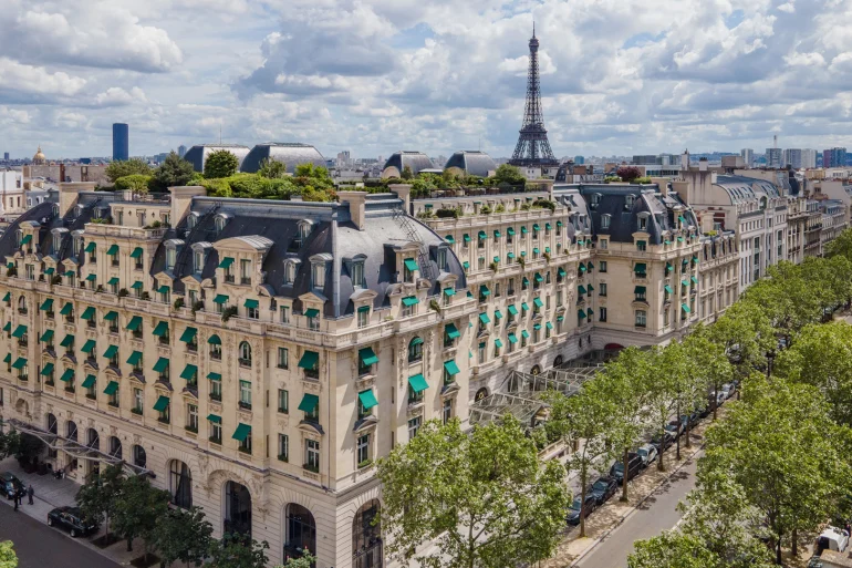 Vue aérienne de l'hôtel The Peninsula Paris, avenue Kléber, avec la tour Eiffel à l'horizon